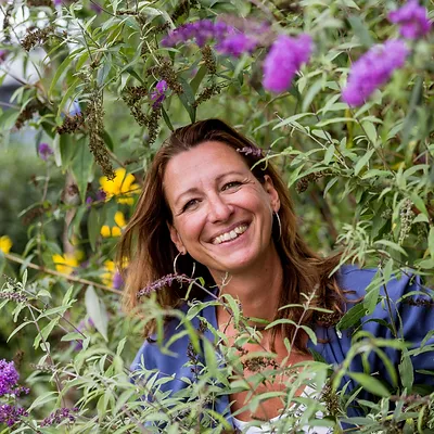 Profilbild von Angelika Wostal – Mentaltrainerin in Fernitz bei Graz – mit Blumen und Pflanzen im Hintergrund